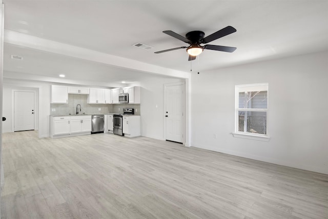 unfurnished living room with ceiling fan, sink, and light hardwood / wood-style flooring