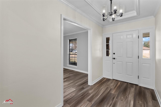 foyer entrance with dark hardwood / wood-style floors, ornamental molding, and a chandelier