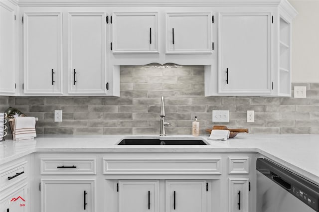 kitchen with stainless steel dishwasher, white cabinetry, sink, and tasteful backsplash