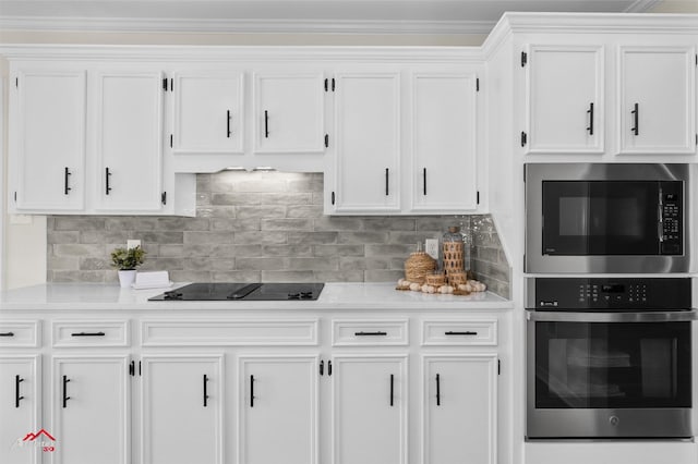 kitchen with backsplash, black electric stovetop, and white cabinets