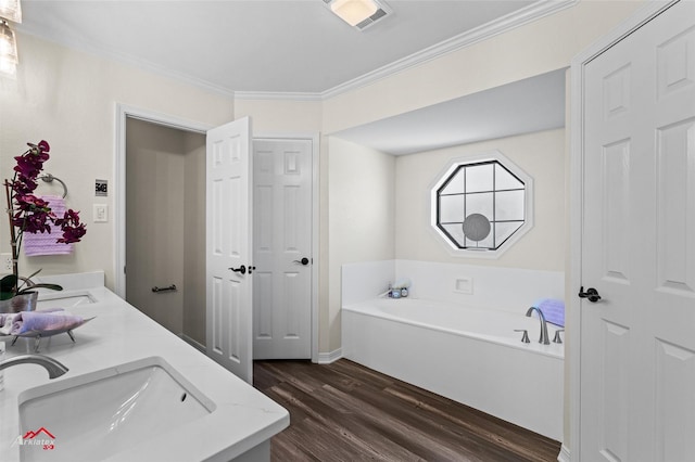 bathroom with a washtub, wood-type flooring, vanity, and crown molding