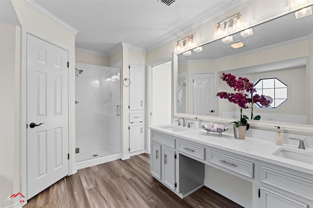 bathroom with vanity, crown molding, wood-type flooring, and walk in shower