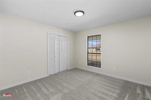 unfurnished bedroom featuring carpet flooring and a closet