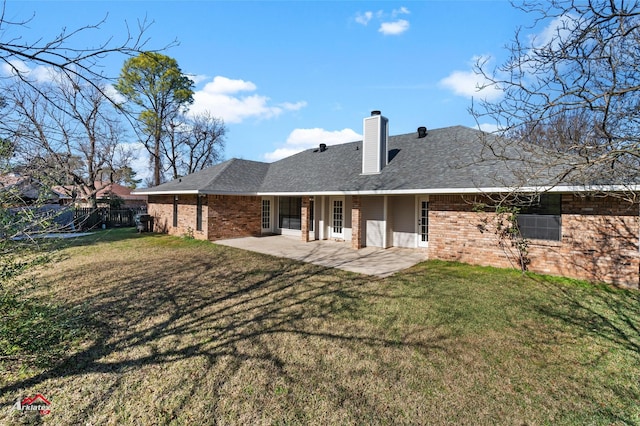 back of property featuring a lawn and a patio