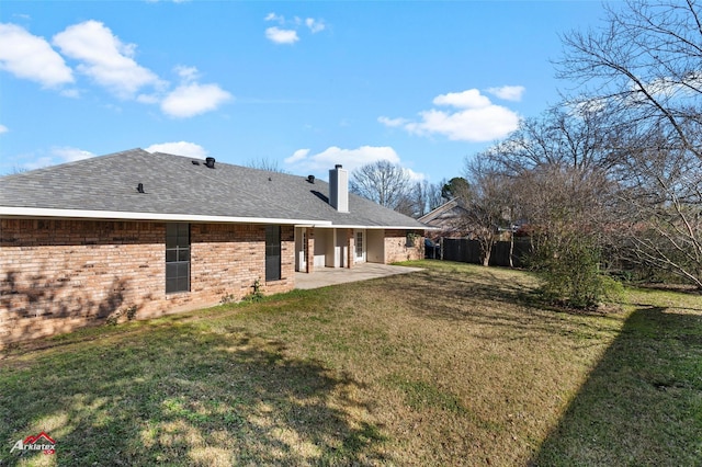 rear view of house with a yard and a patio