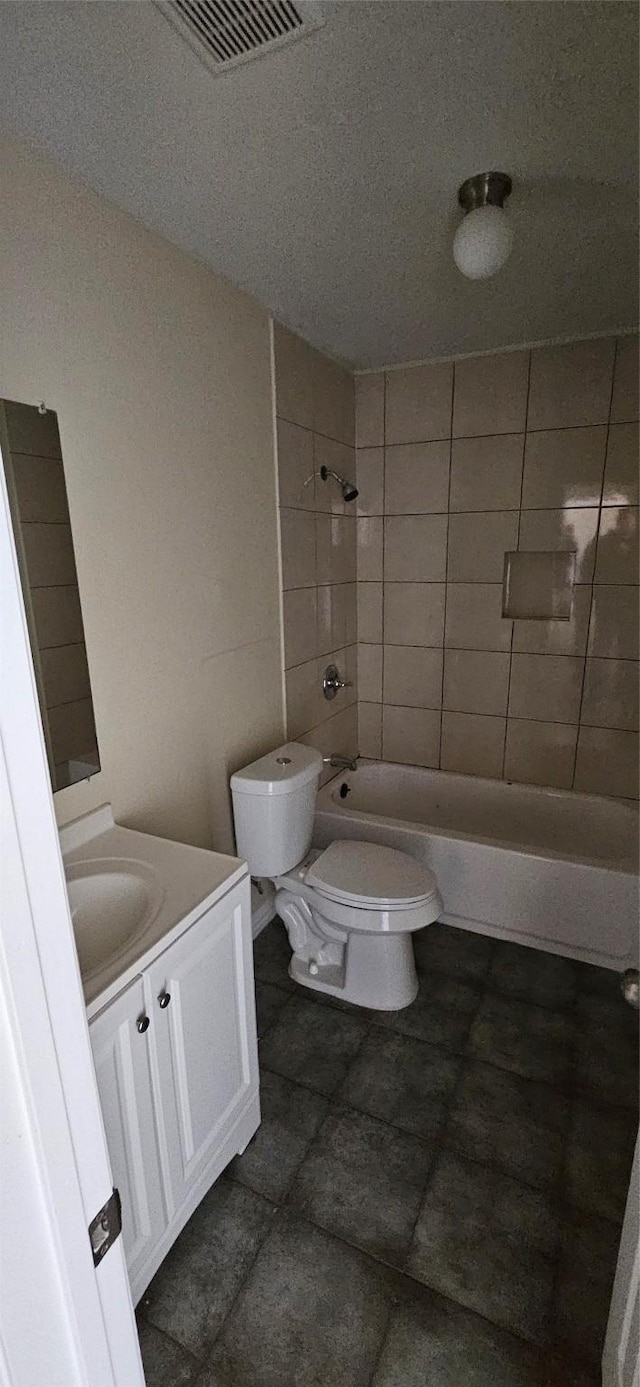 full bathroom featuring vanity, tiled shower / bath combo, and toilet