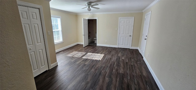 unfurnished bedroom featuring ceiling fan, multiple closets, crown molding, and dark wood-type flooring