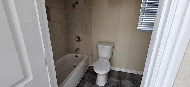 bathroom featuring tiled shower / bath combo and toilet