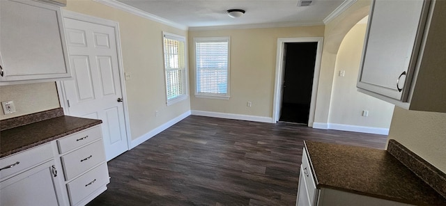 interior space with dark hardwood / wood-style floors, white cabinetry, and ornamental molding