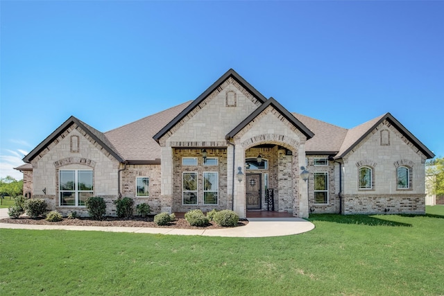 french provincial home featuring a front yard