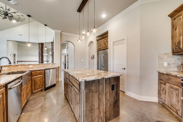 kitchen with a center island, sink, ceiling fan, decorative backsplash, and appliances with stainless steel finishes