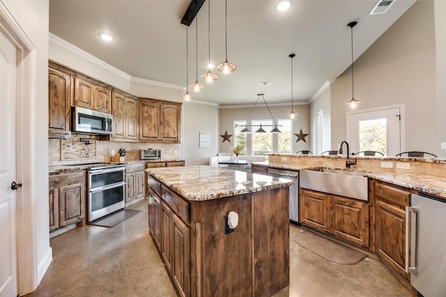 kitchen featuring a center island, sink, decorative backsplash, appliances with stainless steel finishes, and decorative light fixtures