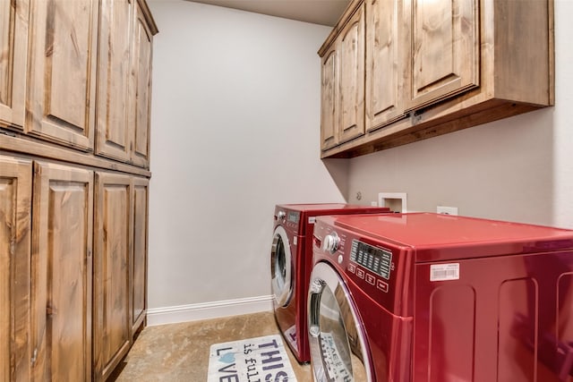 washroom with cabinets and washing machine and clothes dryer