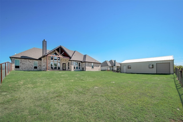 rear view of house featuring an outbuilding, a yard, and a garage