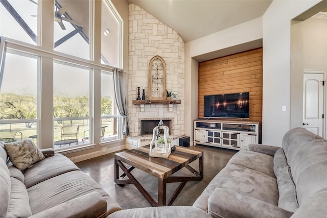 living room with high vaulted ceiling and a stone fireplace