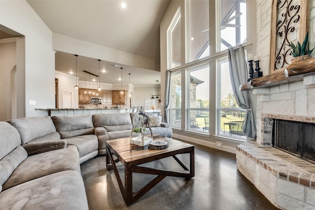 living room featuring a high ceiling, a stone fireplace, and crown molding