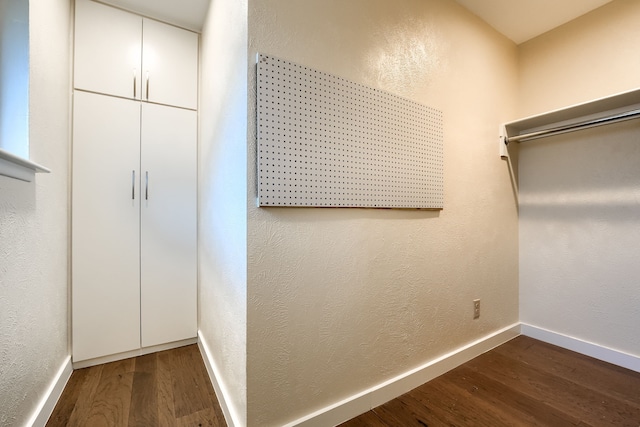 walk in closet with dark hardwood / wood-style floors