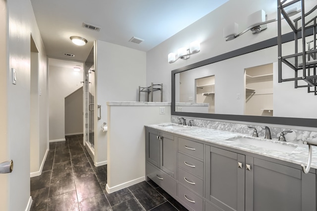 bathroom featuring a shower with door and vanity