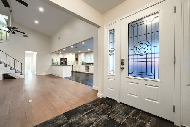 entryway featuring dark wood-type flooring, ceiling fan, and high vaulted ceiling