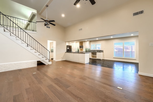 unfurnished living room with ceiling fan, dark hardwood / wood-style flooring, and high vaulted ceiling