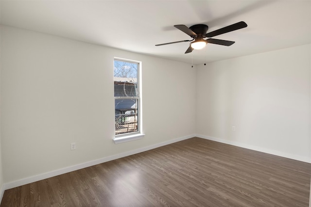 spare room with dark hardwood / wood-style floors and ceiling fan