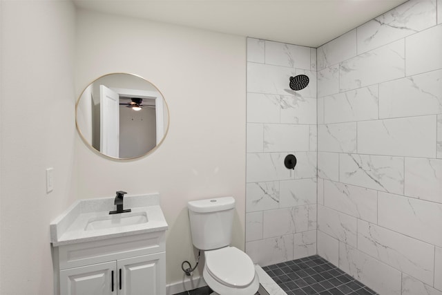 bathroom featuring vanity, tiled shower, and toilet