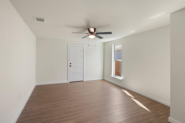 unfurnished room featuring dark wood-type flooring and ceiling fan