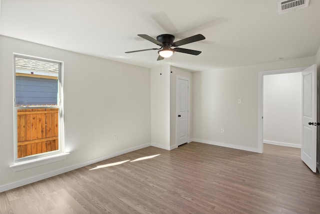 empty room with ceiling fan and light hardwood / wood-style flooring