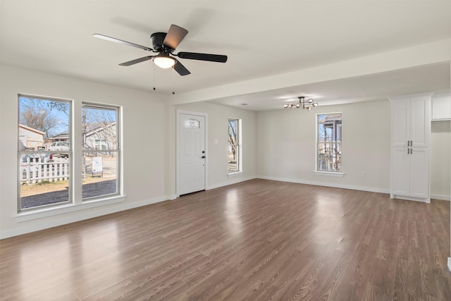 interior space featuring dark hardwood / wood-style flooring and ceiling fan with notable chandelier