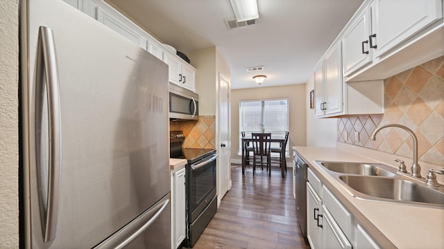 kitchen featuring sink, appliances with stainless steel finishes, dark hardwood / wood-style floors, tasteful backsplash, and white cabinets