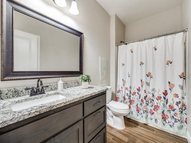 bathroom with a shower with shower curtain, vanity, toilet, and hardwood / wood-style floors