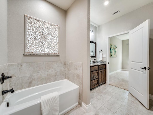 bathroom with tile patterned flooring, vanity, and a washtub