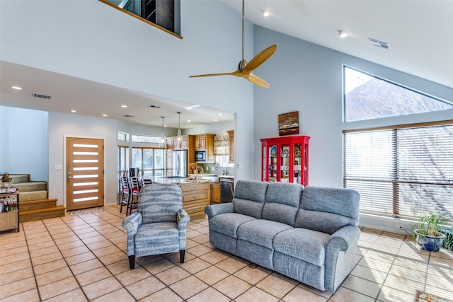 tiled living room with ceiling fan and high vaulted ceiling