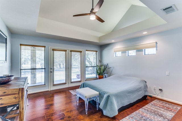 bedroom featuring multiple windows, access to exterior, vaulted ceiling, and dark hardwood / wood-style floors