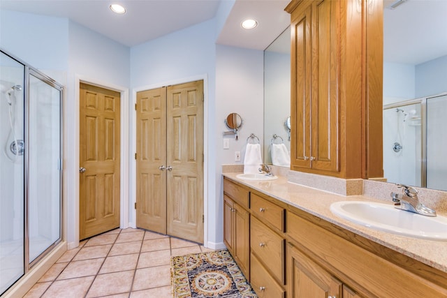 bathroom with tile patterned flooring, vanity, and a shower with door