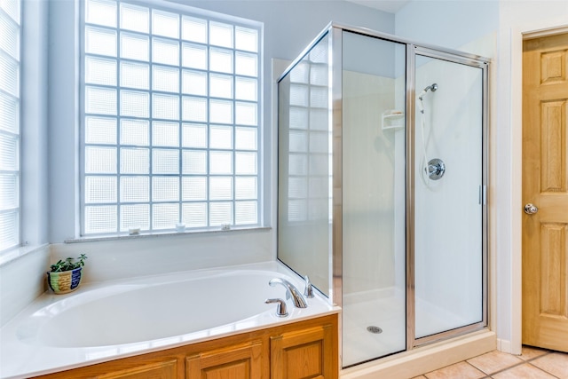 bathroom with plus walk in shower, tile patterned floors, and a wealth of natural light