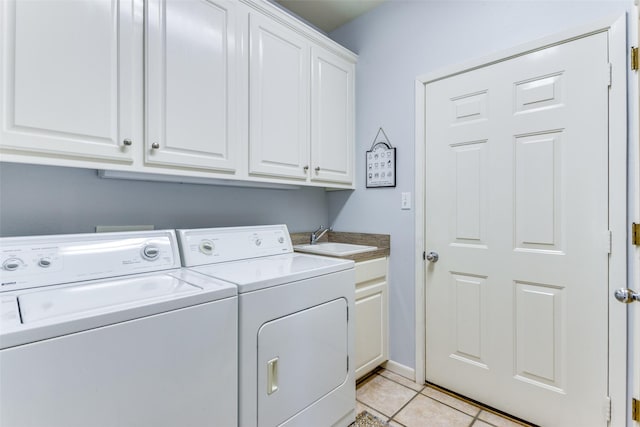 laundry area with cabinets, sink, separate washer and dryer, and light tile patterned flooring