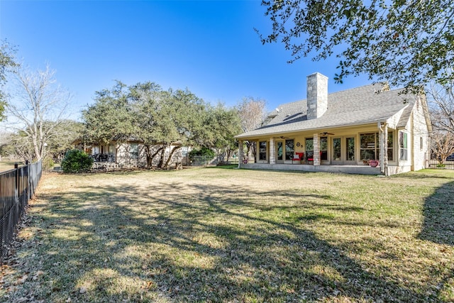 back of property featuring a lawn, a patio area, and ceiling fan