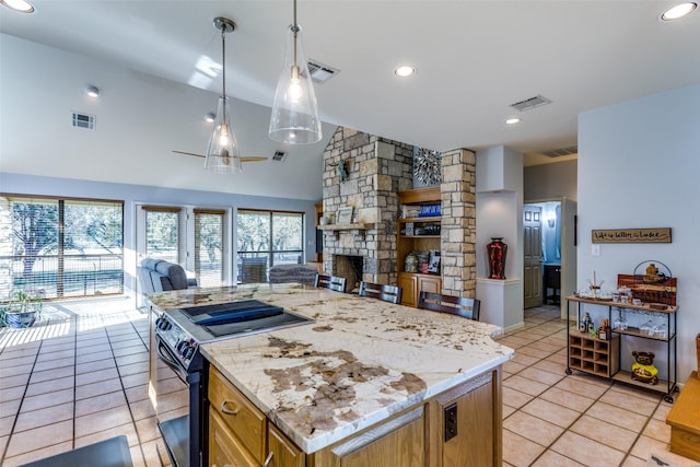 kitchen featuring pendant lighting, a stone fireplace, vaulted ceiling, electric range, and light tile patterned flooring