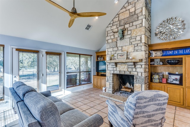 tiled living room featuring ceiling fan, a fireplace, high vaulted ceiling, and a healthy amount of sunlight