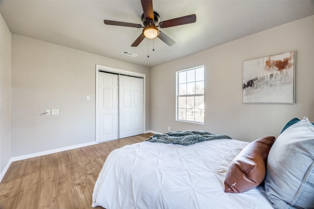 bedroom featuring ceiling fan, light hardwood / wood-style floors, and a closet