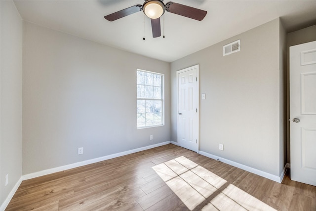 spare room with light wood-type flooring and ceiling fan