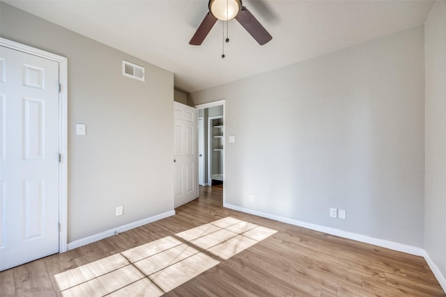 unfurnished bedroom with ceiling fan and light wood-type flooring