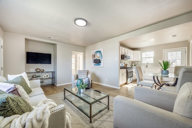 living room with sink and light hardwood / wood-style flooring