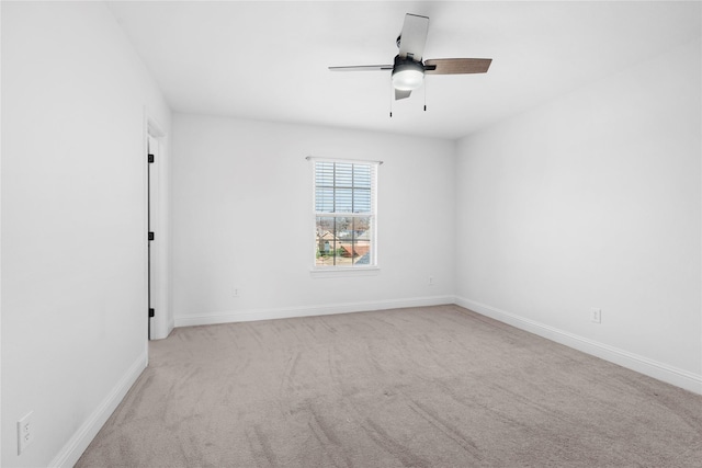 empty room with baseboards, ceiling fan, and light colored carpet