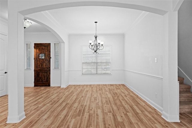 unfurnished dining area featuring an inviting chandelier, light hardwood / wood-style flooring, and ornamental molding