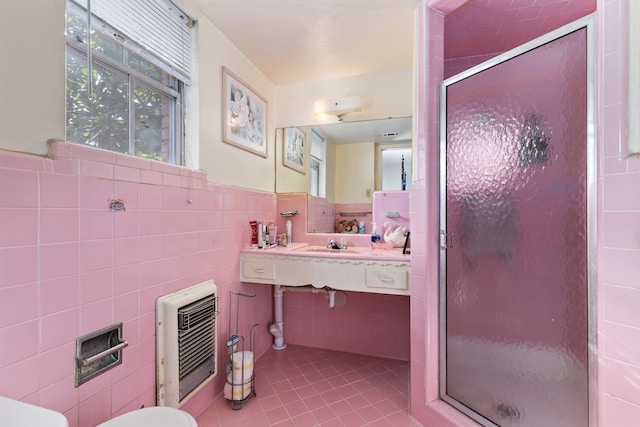 bathroom featuring walk in shower, tile patterned flooring, heating unit, and tile walls