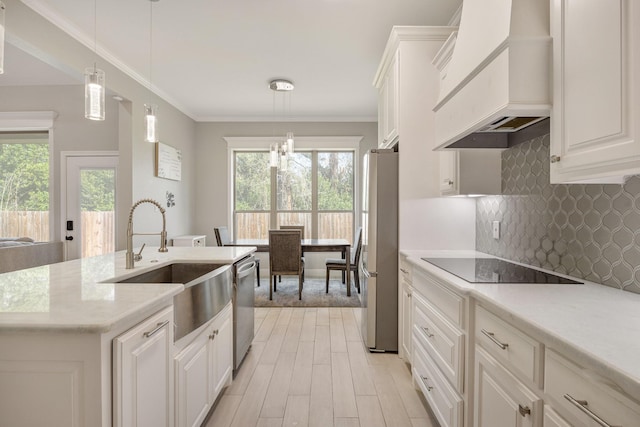 kitchen featuring premium range hood, white cabinetry, hanging light fixtures, and appliances with stainless steel finishes