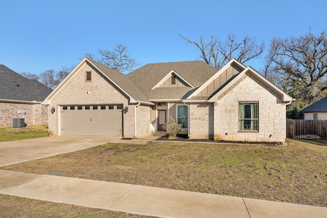 view of front of property featuring central AC, a front yard, and a garage