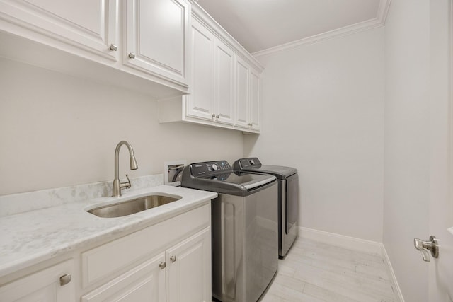 laundry area with cabinets, sink, light hardwood / wood-style flooring, washer and dryer, and ornamental molding